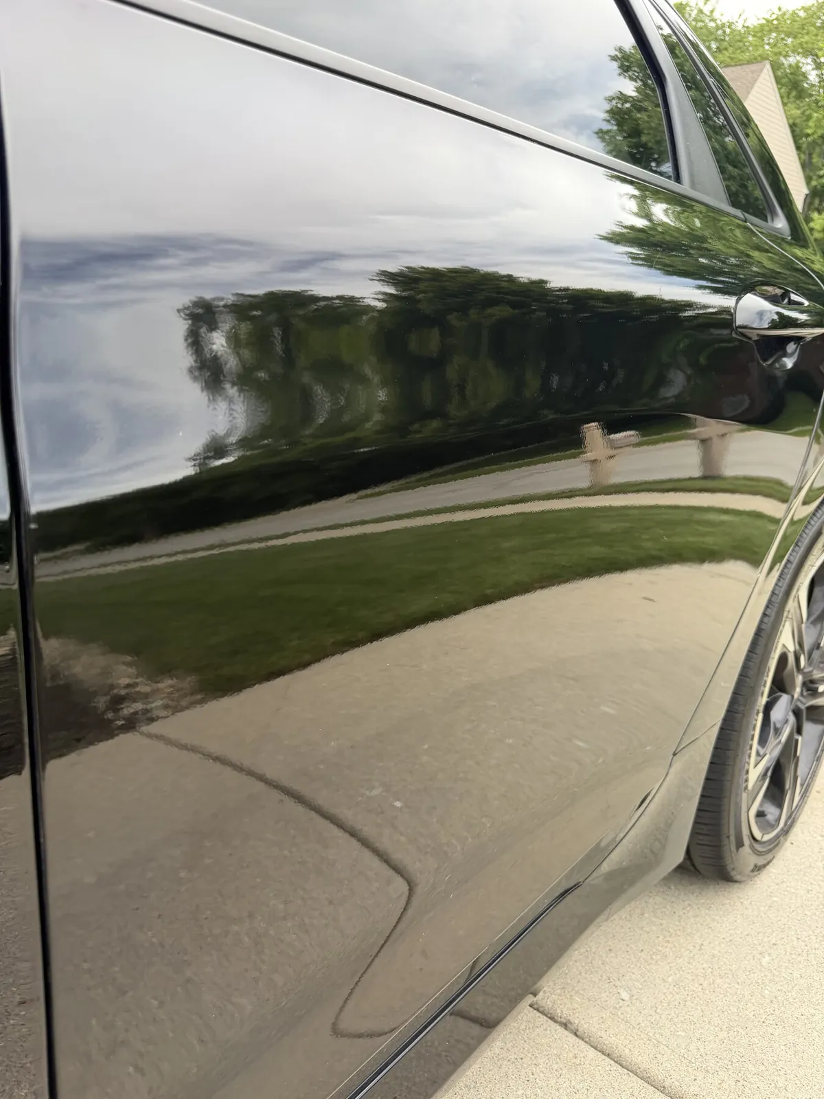 Close up of black car paint gloss and reflection after paint correction and polish